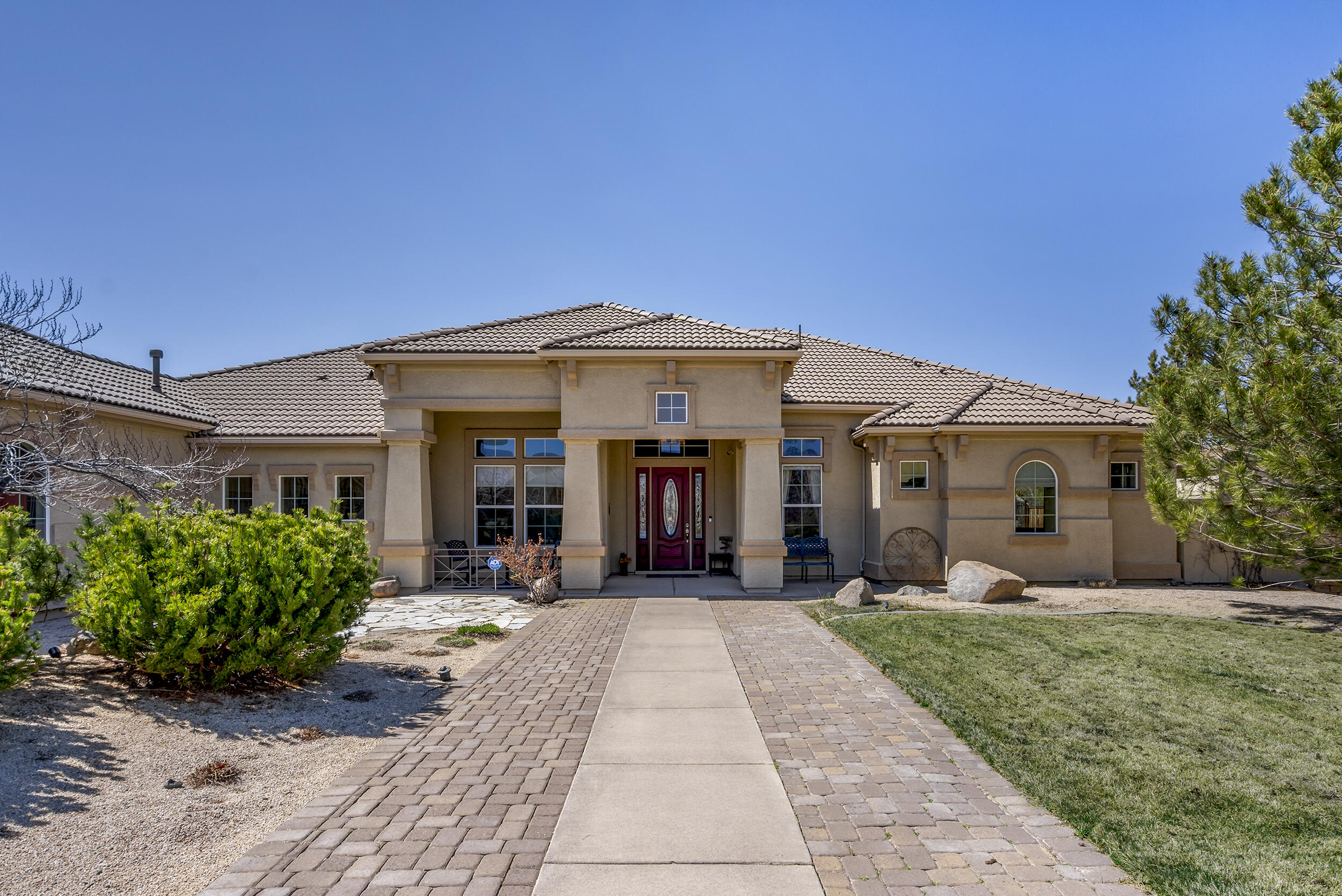 a front view of a house with a yard and potted plants