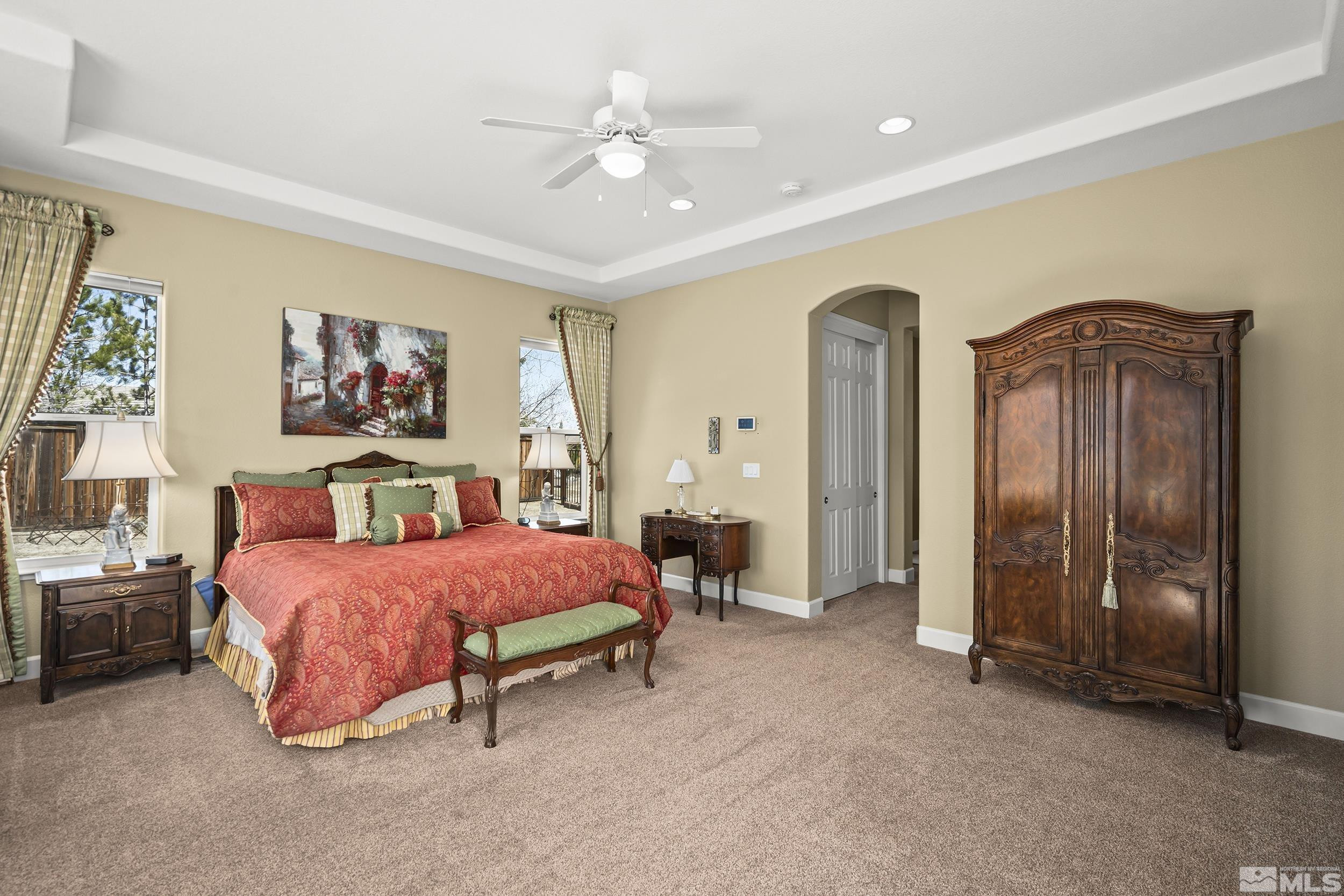 15300 Redmond Loop Reno, NV 89511 - Photo 18 of 35 a spacious bedroom with a bed and a chandelier