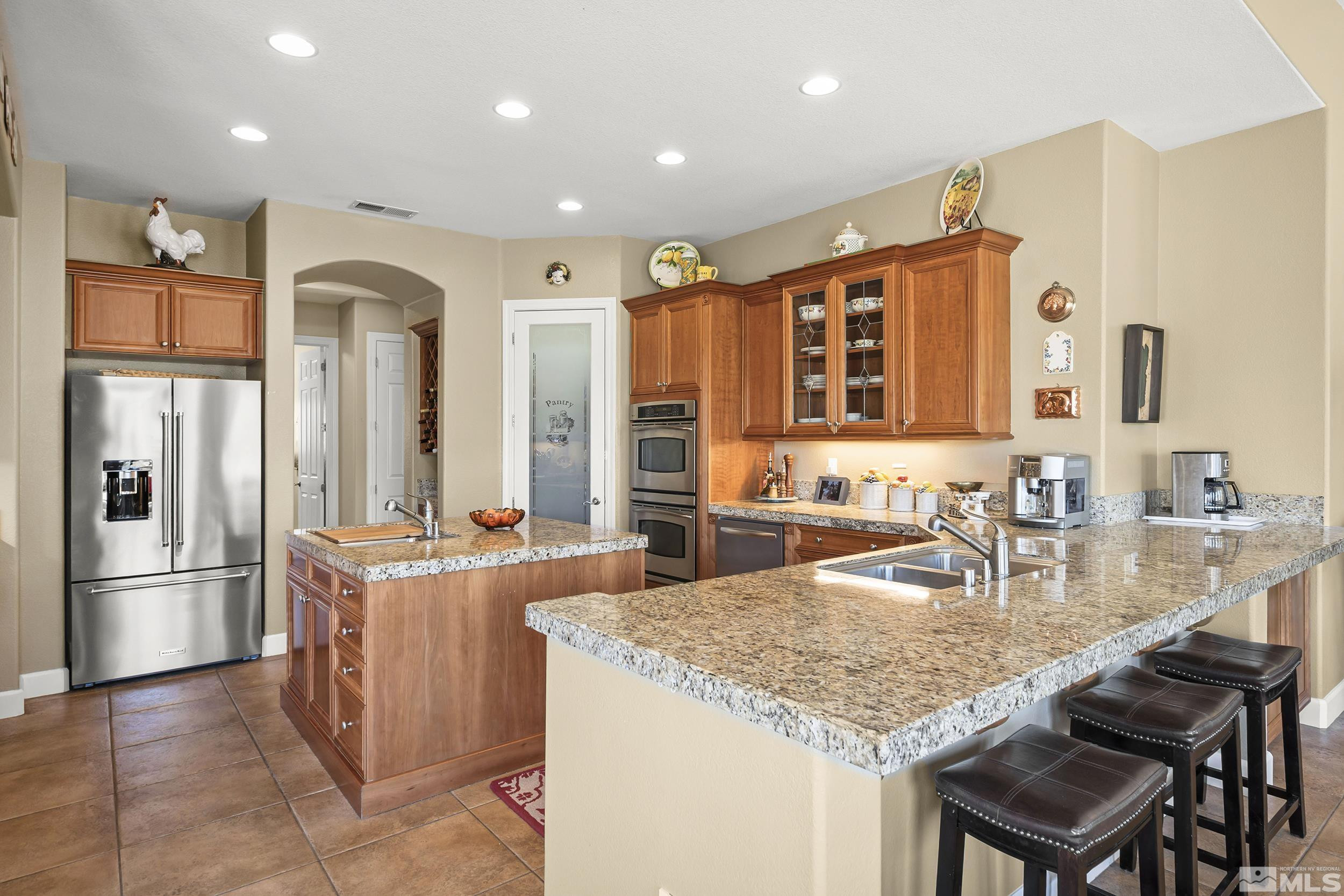15300 Redmond Loop Reno, NV 89511 - Photo 5 of 35 a kitchen with granite countertop a table chairs microwave and refrigerator