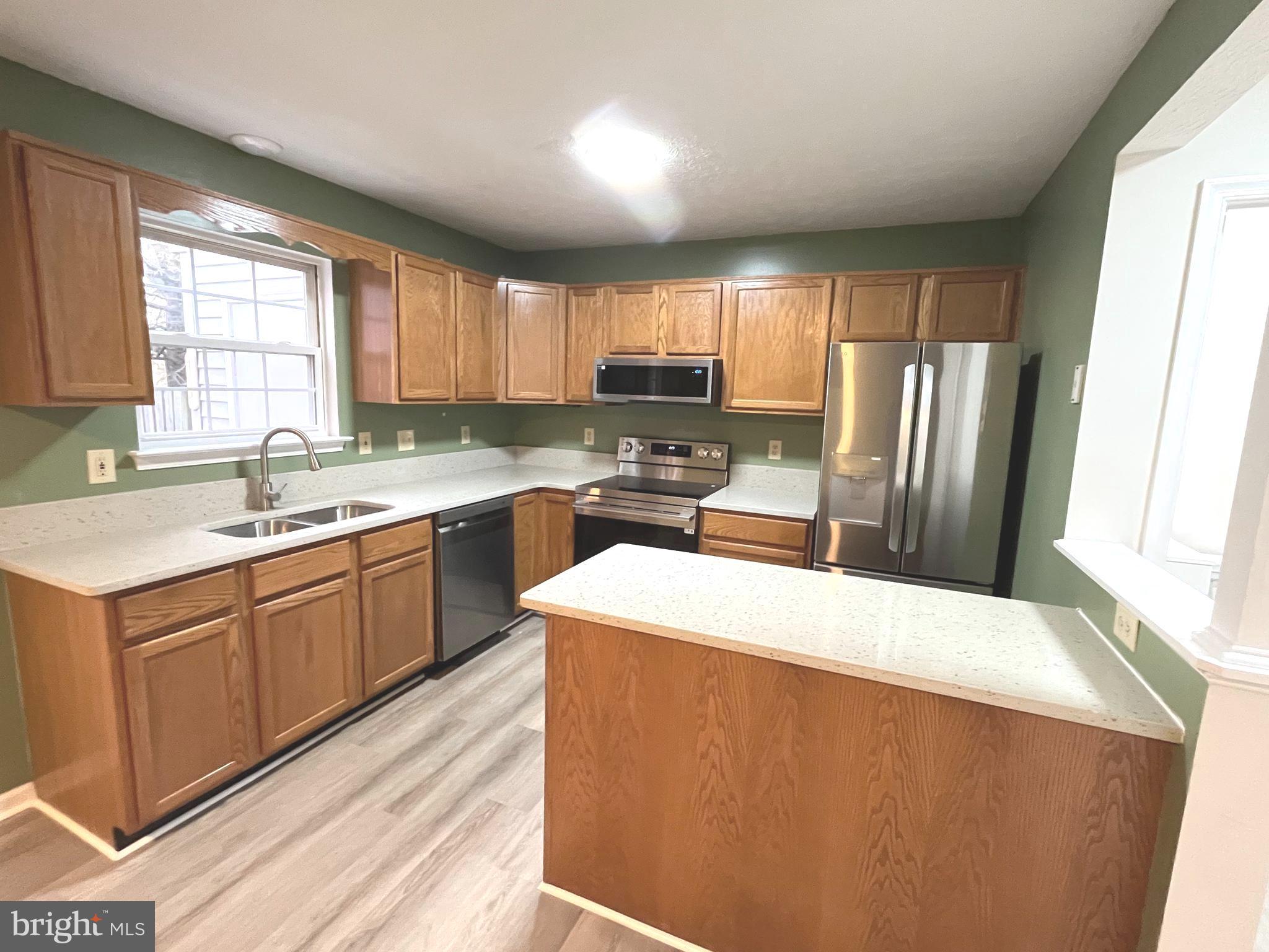 305 Sutton Court Winchester, VA 22601 - Photo 11 of 40 a kitchen with stainless steel appliances sink a microwave and cabinets