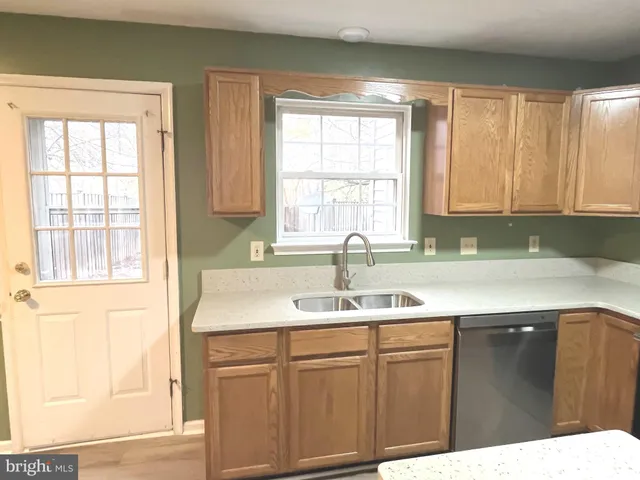 a kitchen with a sink window and cabinets