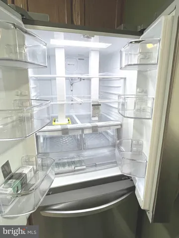 a kitchen with stainless steel appliances granite countertop a refrigerator a sink a stove a microwave and island with wooden cabinets