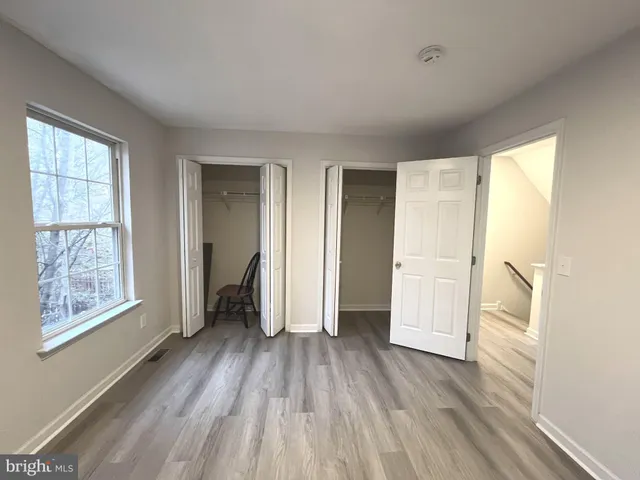 a view of hallway with a large window and wooden floor