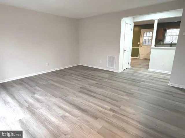 a view of a livingroom with wooden floor and staircase