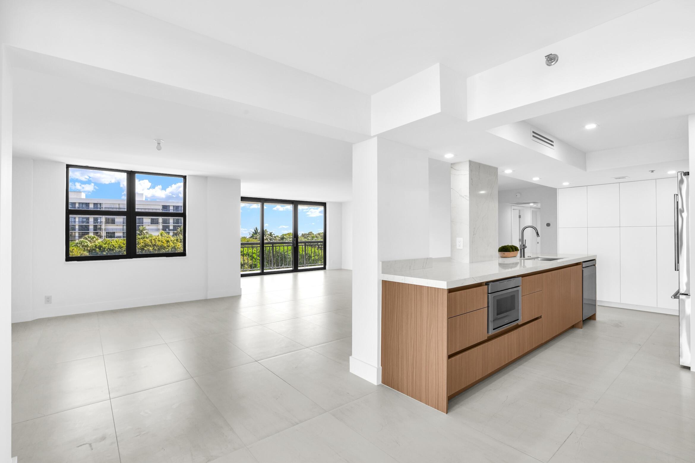2001 North Ocean Boulevard, Unit 502 Boca Raton, FL 33431 - Photo 6 of 67 a large white kitchen with stainless steel appliances granite countertop a large counter top and a stove top oven