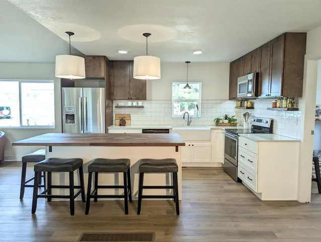 a kitchen with a table chairs refrigerator and microwave
