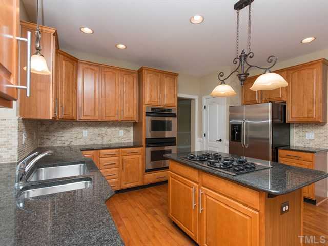 9216 Club Hill Drive Raleigh, NC 27617 - Photo 4 of 25 a kitchen with stainless steel appliances granite countertop a stove a sink and a microwave