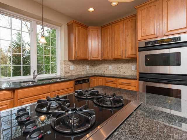 9216 Club Hill Drive Raleigh, NC 27617 - Photo 6 of 25 a kitchen with a stove a sink and a microwave
