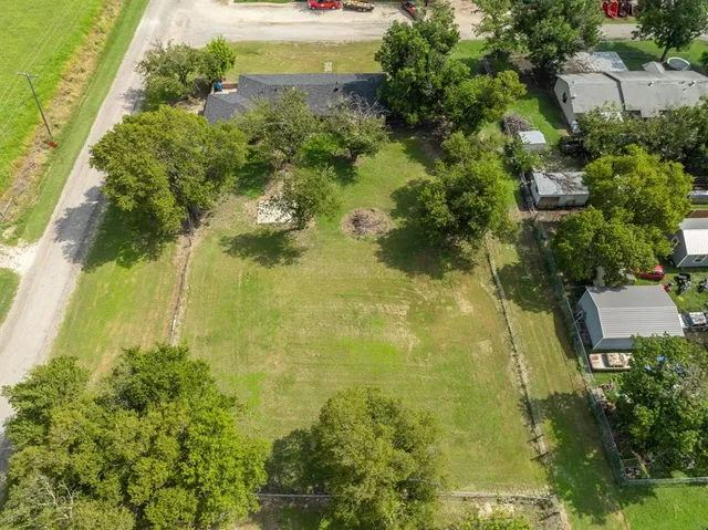 an aerial view of a residential houses with yard