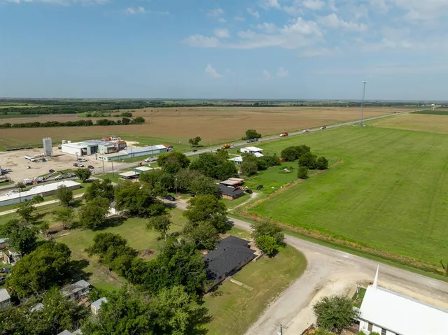 an aerial view of residential houses with outdoor space and trees