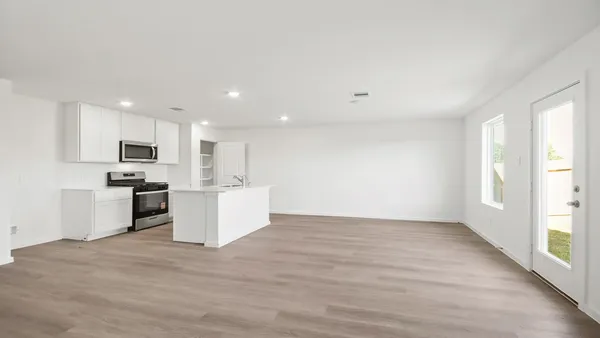 a view of kitchen with microwave oven stove and cabinets