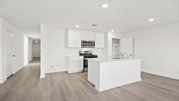 a kitchen with a sink a microwave a refrigerator and cabinets