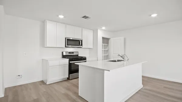 a kitchen with appliances a sink and cabinets