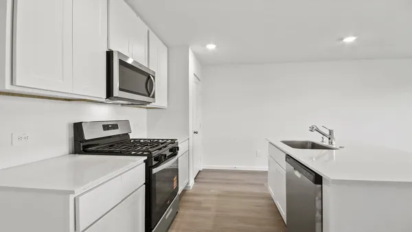 a kitchen with granite countertop a sink stove and microwave