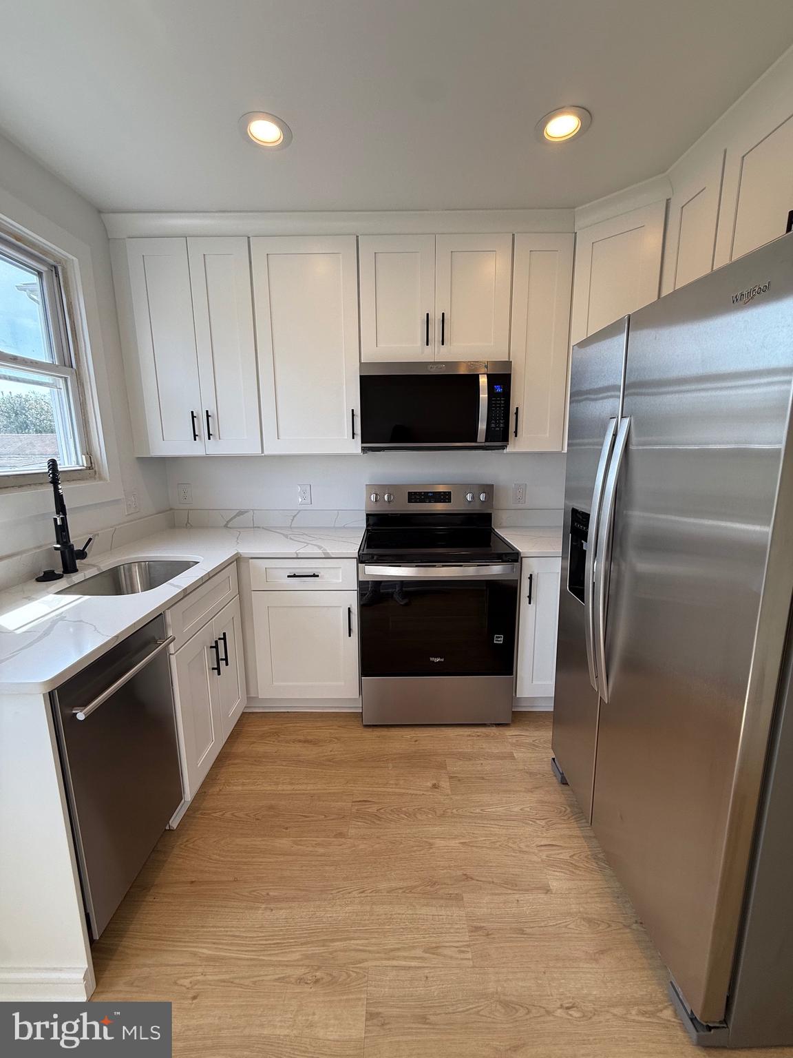2125 Oakland Road Middle River, MD 21220 - Photo 3 of 15 a kitchen with white cabinets stainless steel appliances and a window