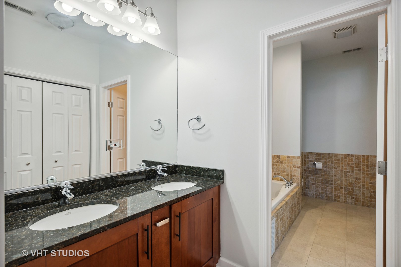 523 North Racine Avenue, Unit 4 Chicago, IL 60642 - Photo 11 of 17 a bathroom with a granite countertop sink and a mirror