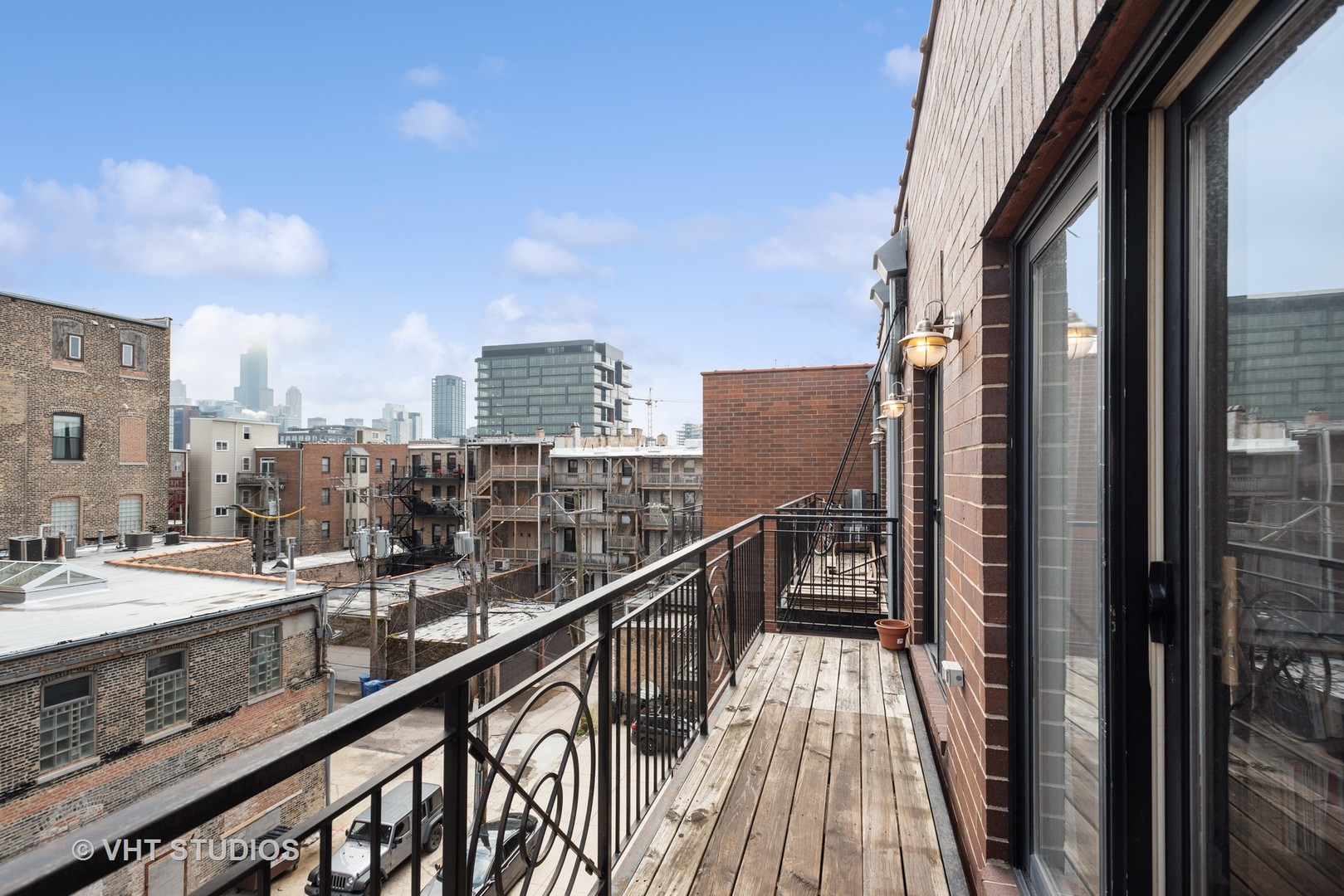 523 North Racine Avenue, Unit 4 Chicago, IL 60642 - Photo 14 of 17 a view of balcony with a couple of cars parked on road with building