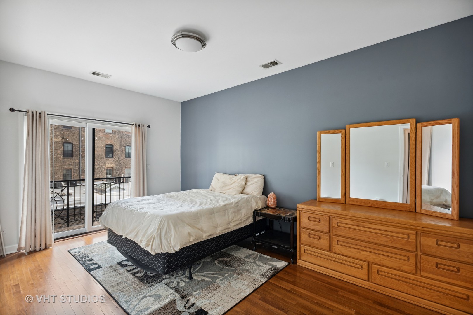 523 North Racine Avenue, Unit 4 Chicago, IL 60642 - Photo 9 of 17 a bedroom with a large bed and a large window