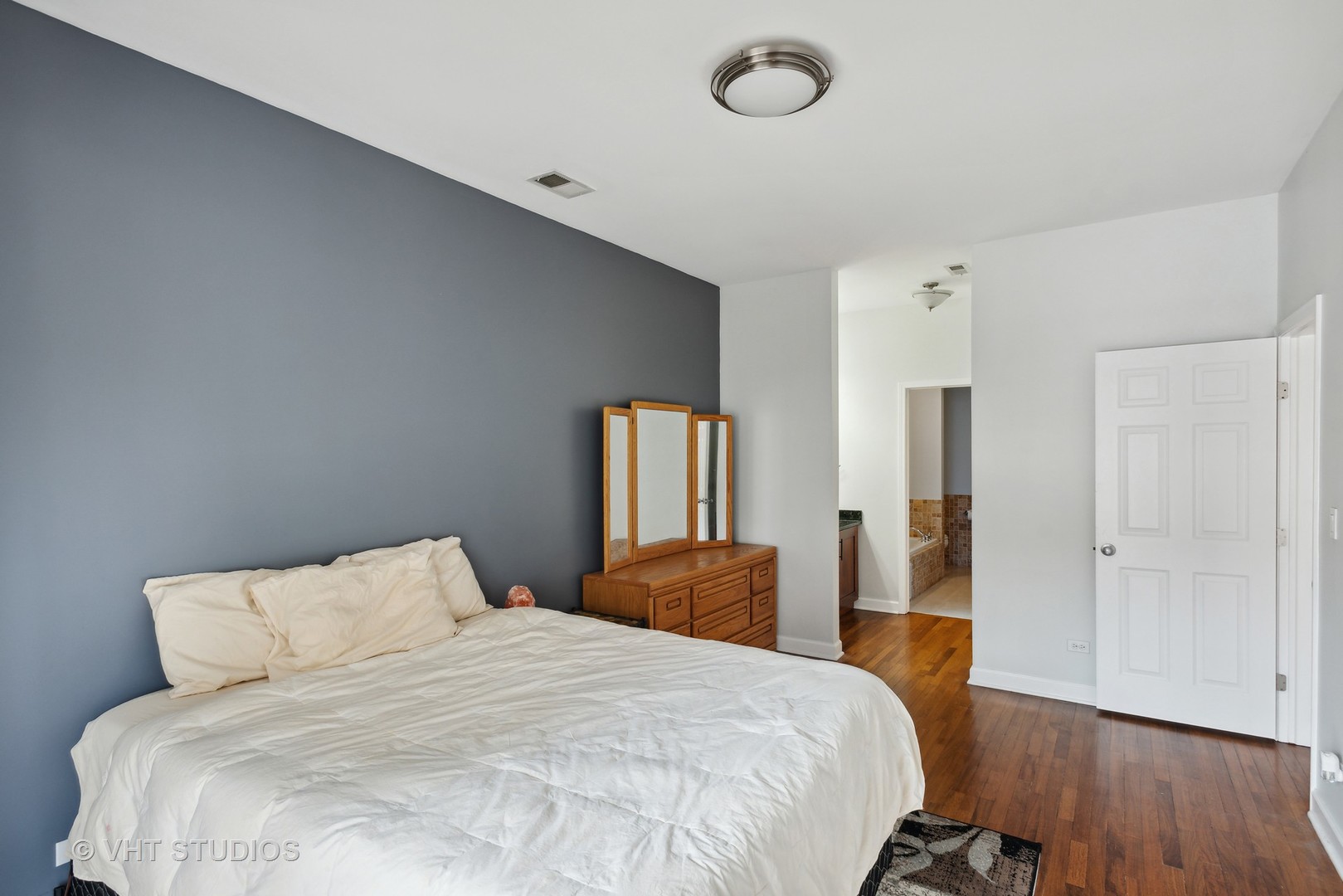 523 North Racine Avenue, Unit 4 Chicago, IL 60642 - Photo 10 of 17 a bedroom with a bed and wooden floor