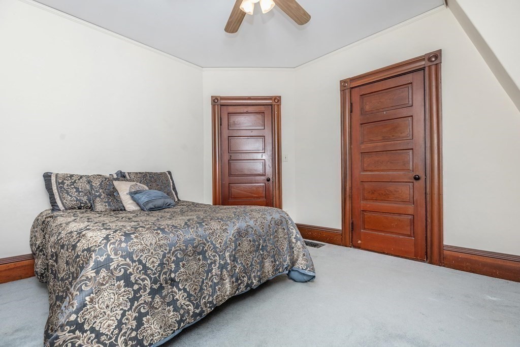 28 Andover Street Peabody, MA 01960 - Photo 20 of 30 a bedroom with a bed and a chandelier fan