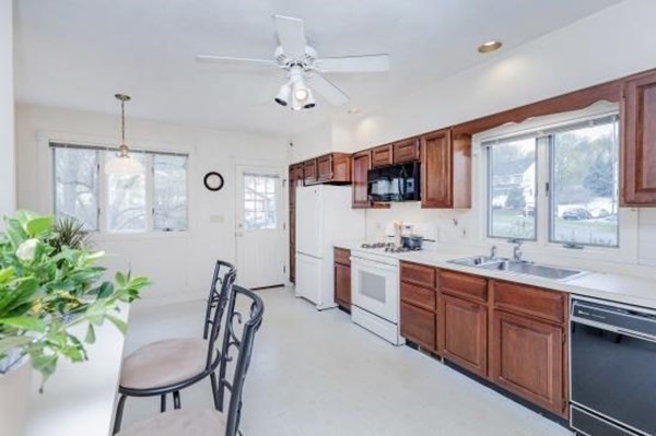 28 Andover Street Peabody, MA 01960 - Photo 6 of 30 a large kitchen with stainless steel appliances a table and chairs in it
