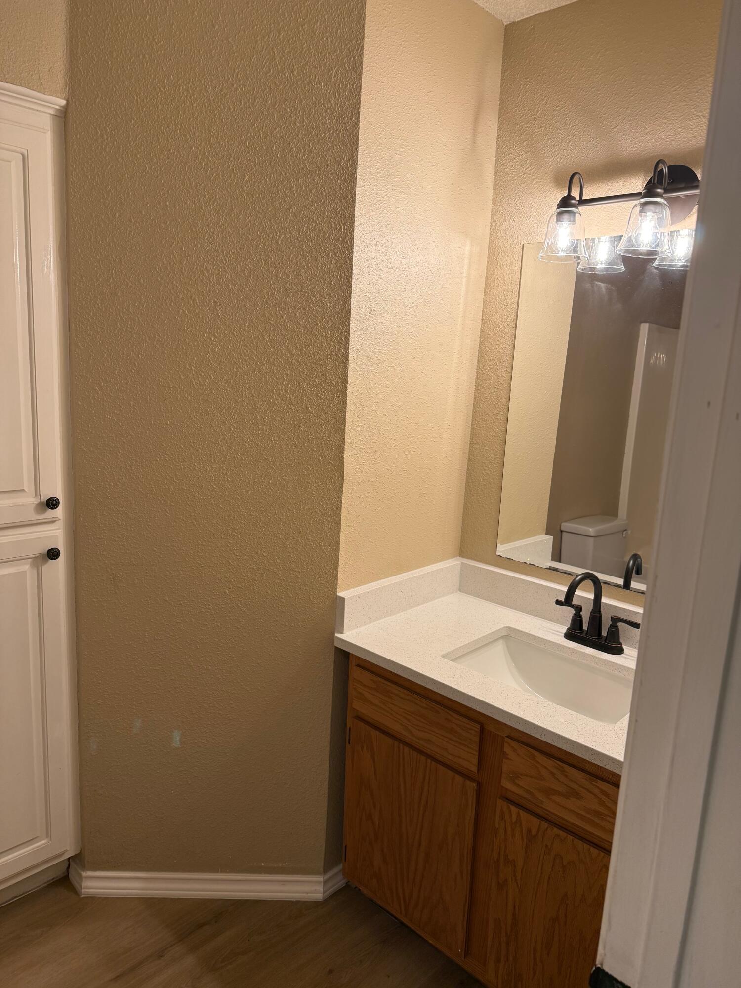 2523 110th Street Lubbock, TX 79423 - Photo 13 of 23 a bathroom with a sink and a mirror
