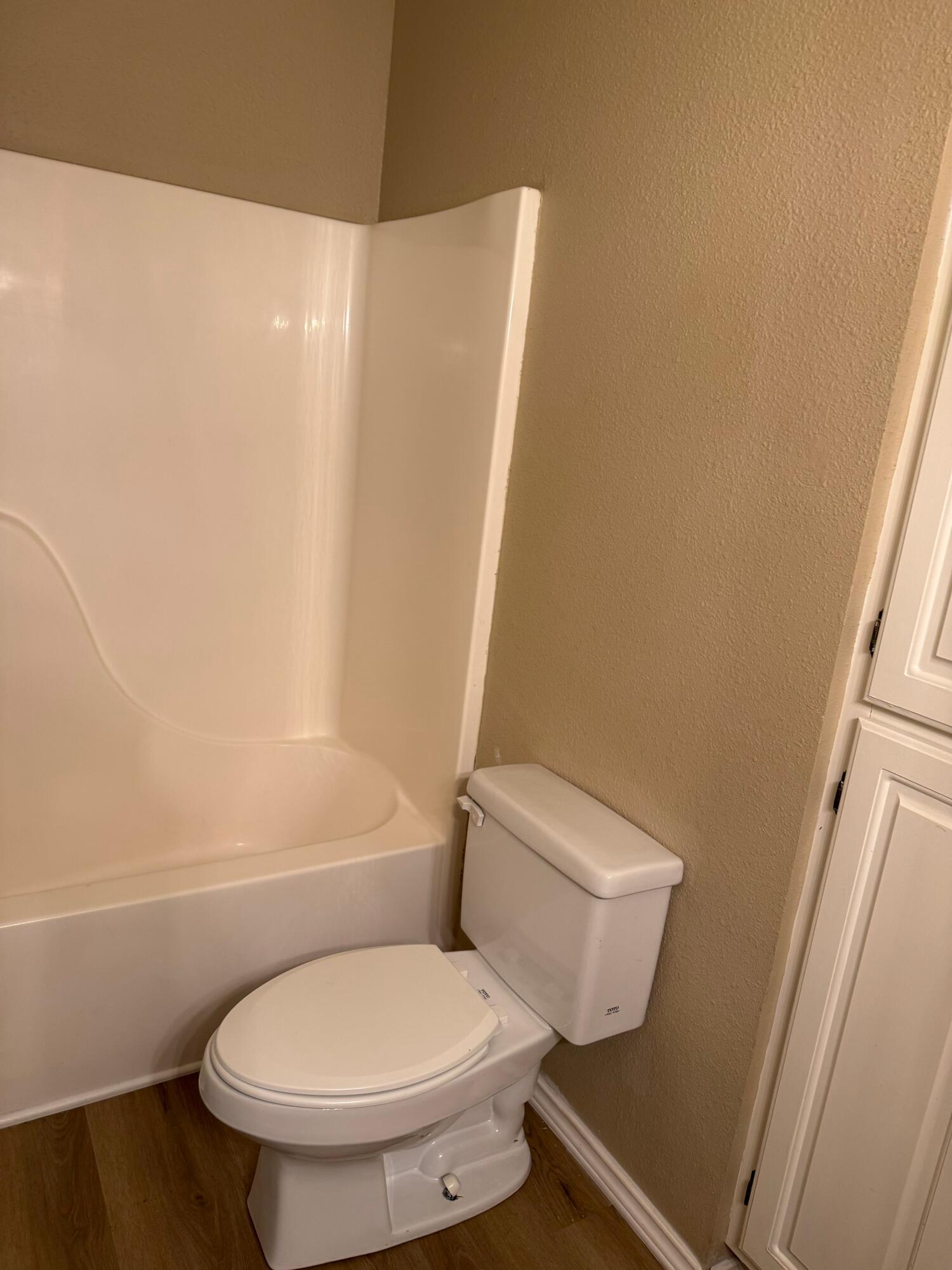 2523 110th Street Lubbock, TX 79423 - Photo 14 of 23 a white toilet sitting next to a shower