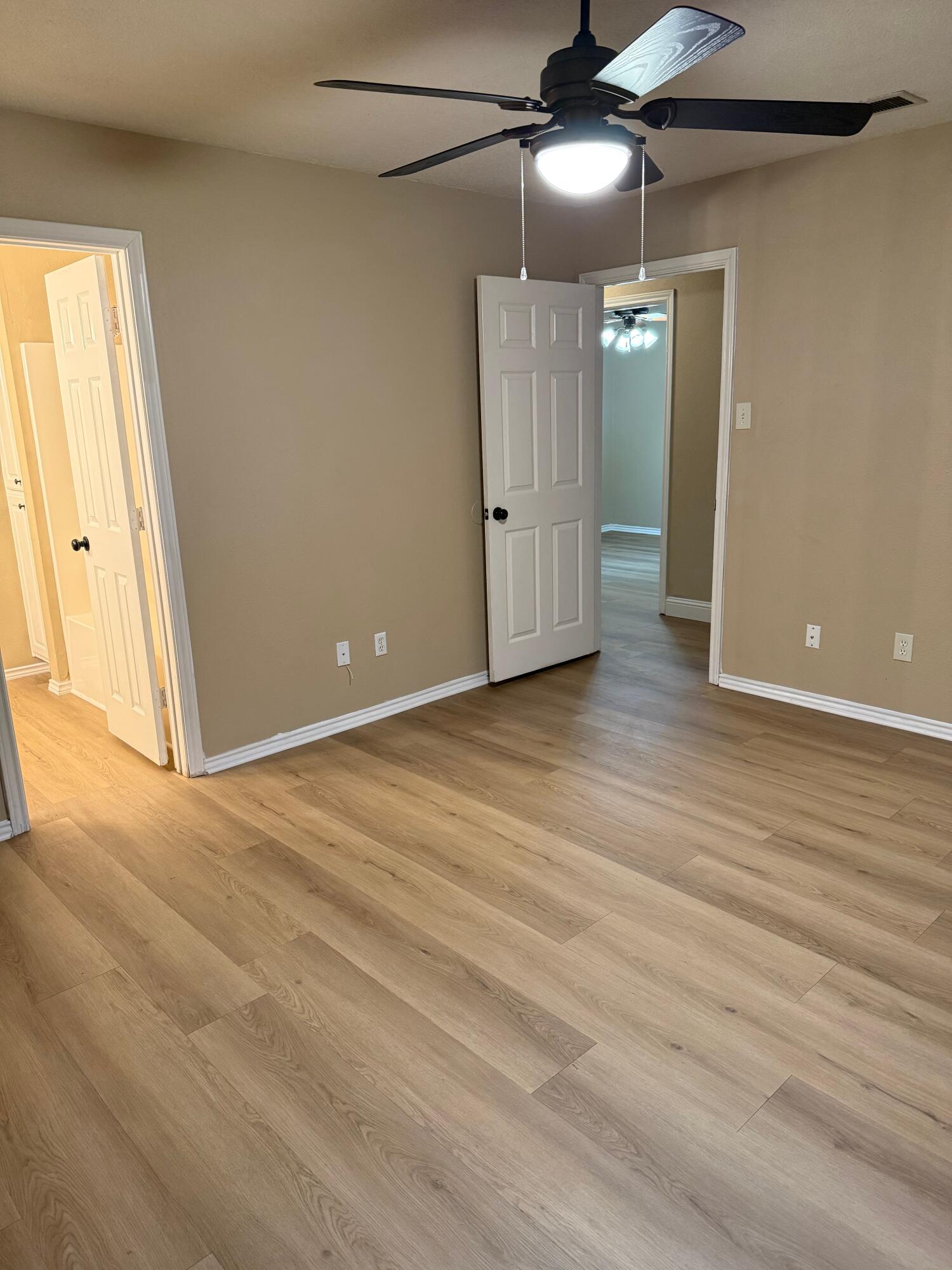 2523 110th Street Lubbock, TX 79423 - Photo 19 of 23 a view of an empty room with wooden floor and a window