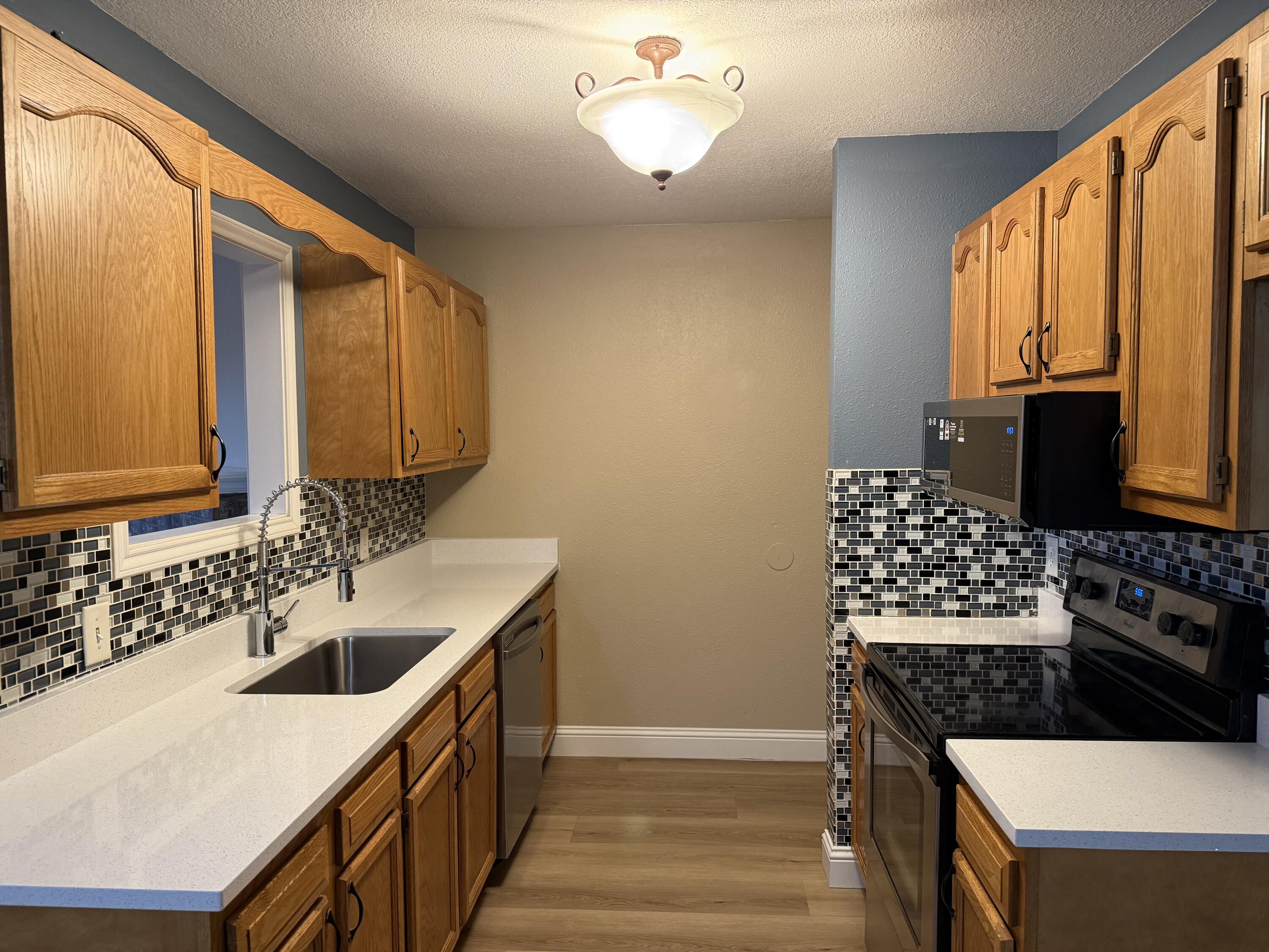 2523 110th Street Lubbock, TX 79423 - Photo 8 of 23 a kitchen with a sink stove and microwave