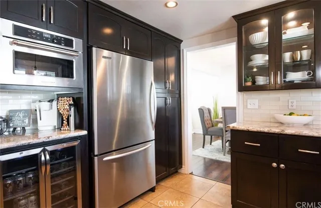 a kitchen with stainless steel appliances granite countertop a sink and wooden cabinets
