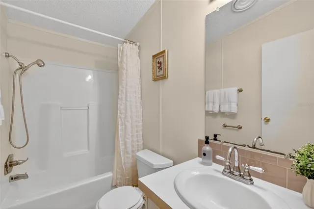 a bathroom with a sink vanity mirror and tub