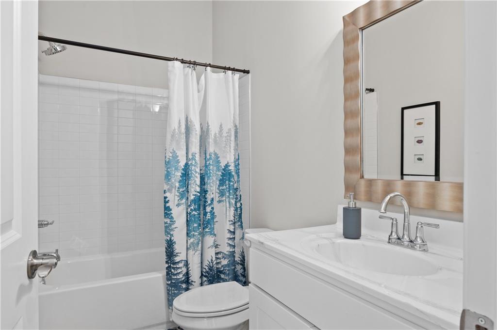 3710 Reserve Overlook Way Cumming, GA 30041 - Photo 13 of 98 a bathroom with a sink a toilet a mirror a bathtub and shower