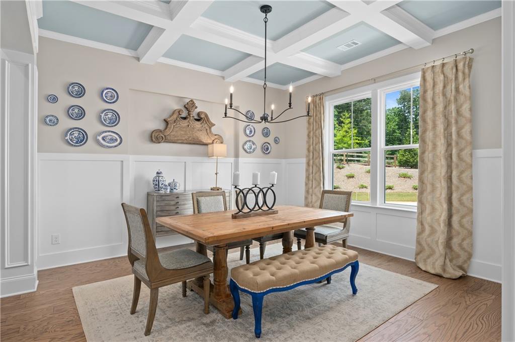 3710 Reserve Overlook Way Cumming, GA 30041 - Photo 14 of 98 a dining room with furniture a chandelier and wooden floor