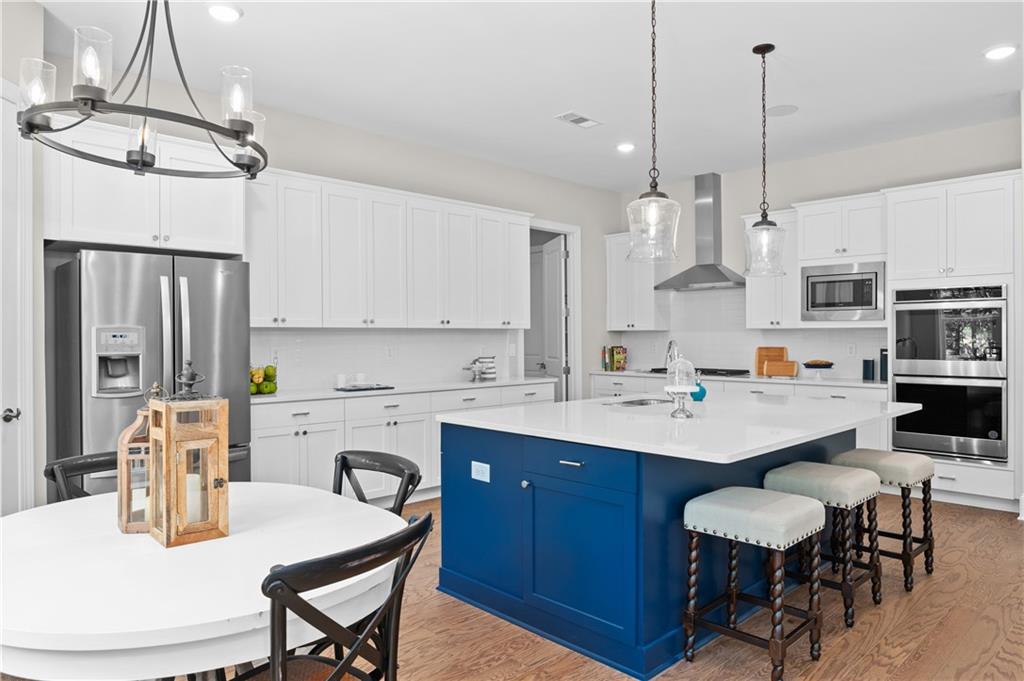 3710 Reserve Overlook Way Cumming, GA 30041 - Photo 26 of 98 a kitchen with stainless steel appliances a sink a stove a table and chairs