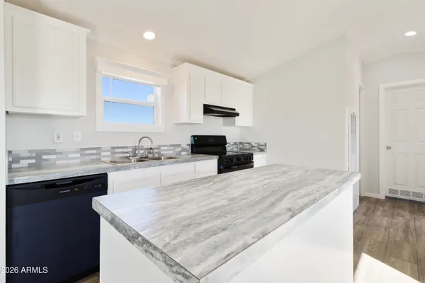 a kitchen with stainless steel appliances granite countertop a sink stove and microwave