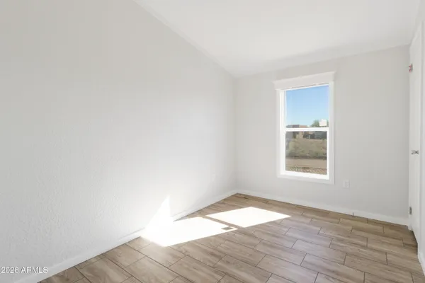 an empty room with wooden floor and window