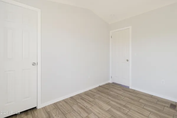 a view of empty room with wooden floor