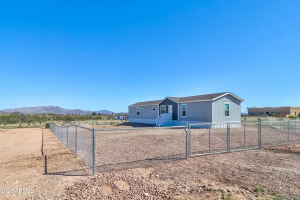 a view of a house with a yard and fence