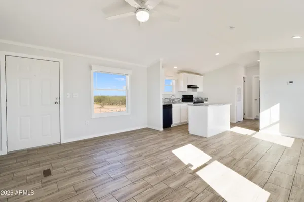 a view of a kitchen with microwave and white cabinets