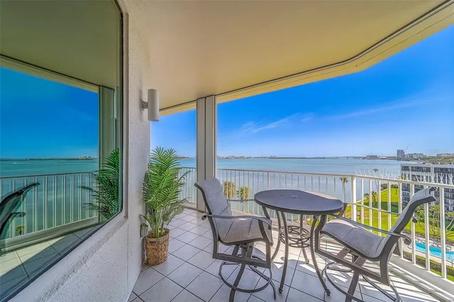 a view of a hallway to a livingroom with wooden floor and furniture
