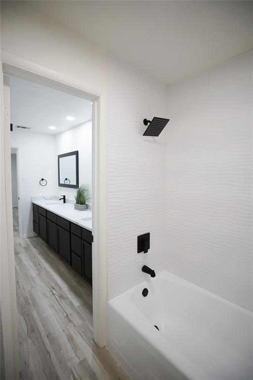 2409 Southwest Sunset Lane Burleson, TX 76028 - Photo 14 of 18 Bathroom with vanity, tiled shower / bath combo, and wood-type flooring