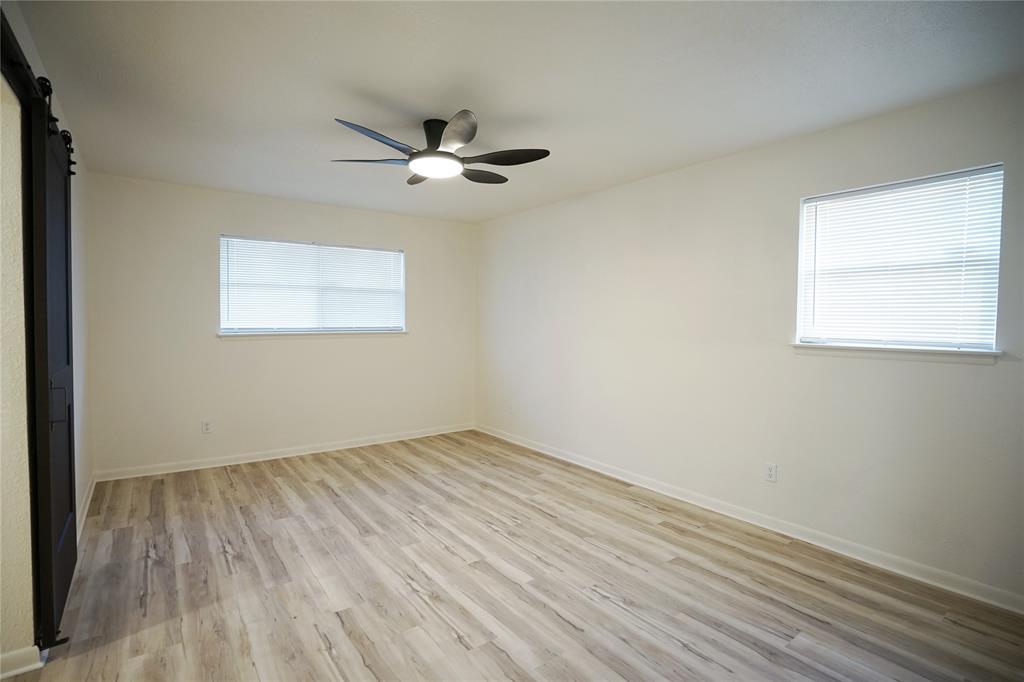 2409 Southwest Sunset Lane Burleson, TX 76028 - Photo 8 of 18 Spare room with light hardwood / wood-style floors, ceiling fan, and a barn door