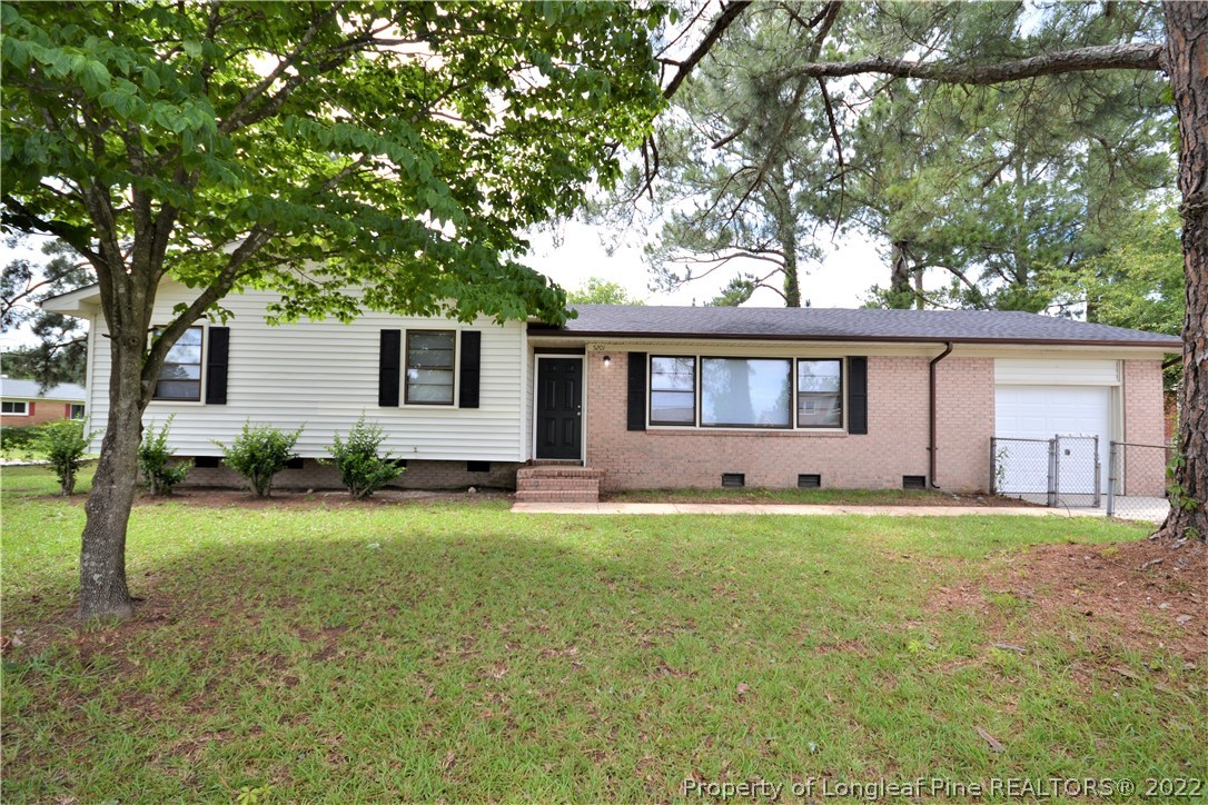 5201 Brookfield Road Fayetteville, NC 28303 - Photo 1 of 45 a front view of a house with a garden and trees