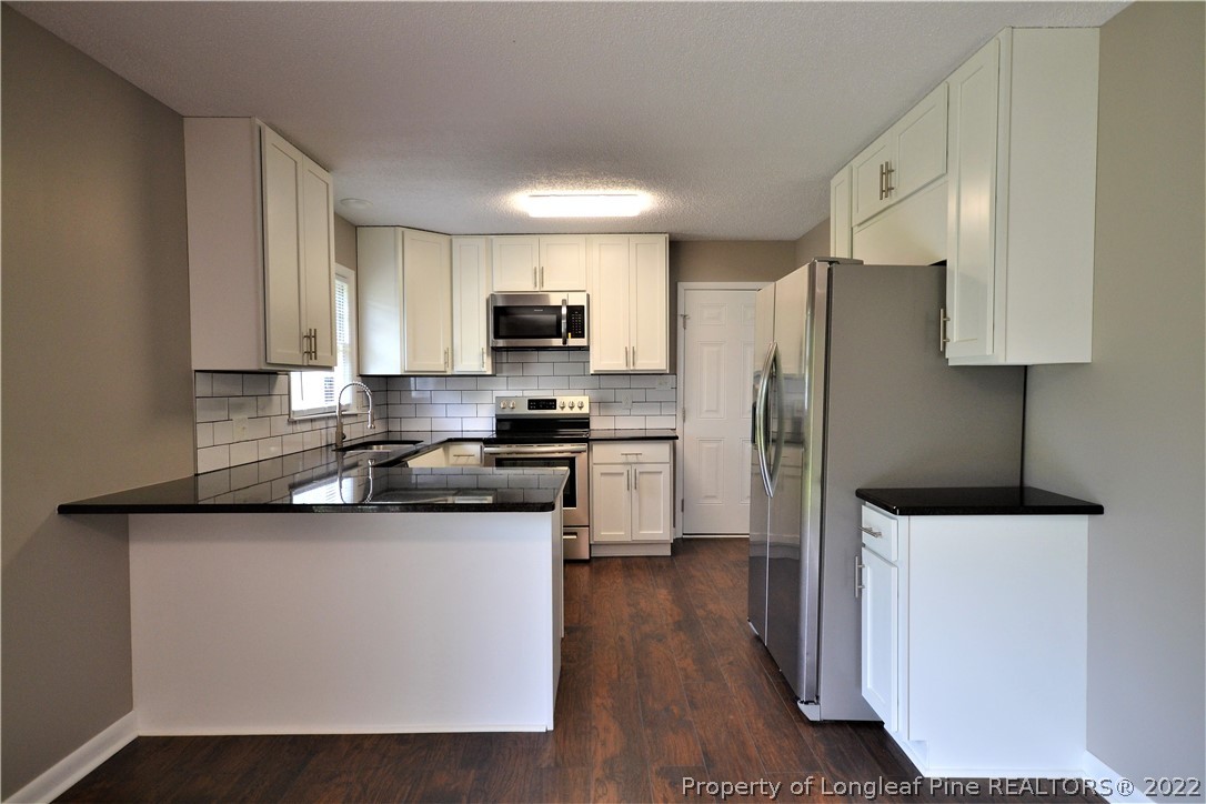 5201 Brookfield Road Fayetteville, NC 28303 - Photo 13 of 45 a kitchen with stainless steel appliances a refrigerator stove microwave and sink