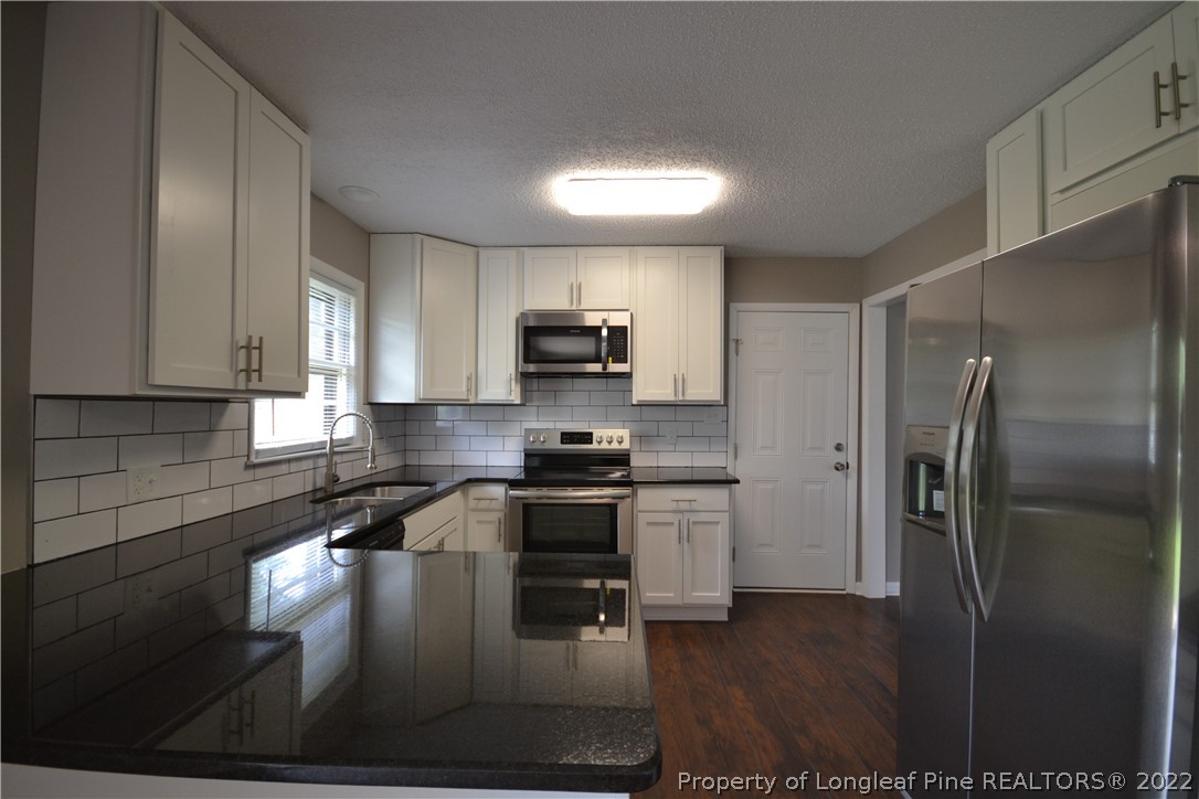 5201 Brookfield Road Fayetteville, NC 28303 - Photo 15 of 45 a kitchen with stainless steel appliances granite countertop a refrigerator a stove top oven a sink and dishwasher
