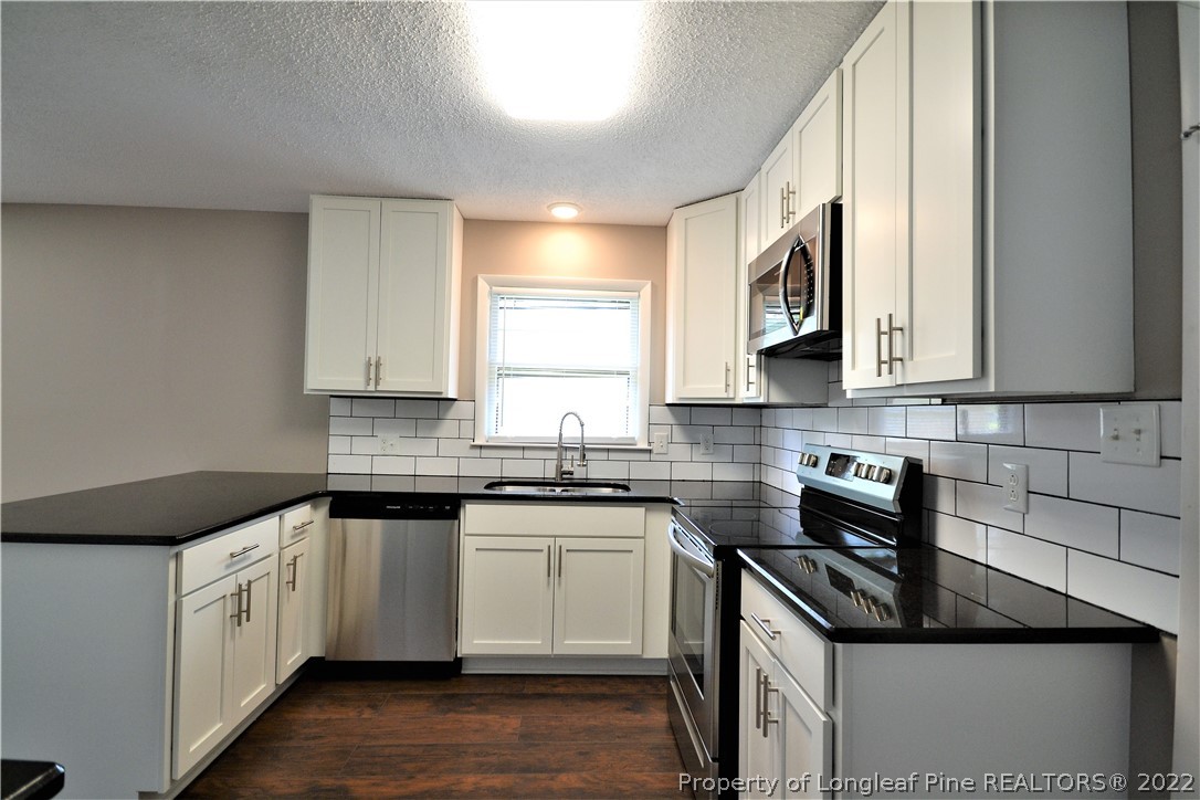 5201 Brookfield Road Fayetteville, NC 28303 - Photo 16 of 45 a kitchen that has a sink and a stove in it