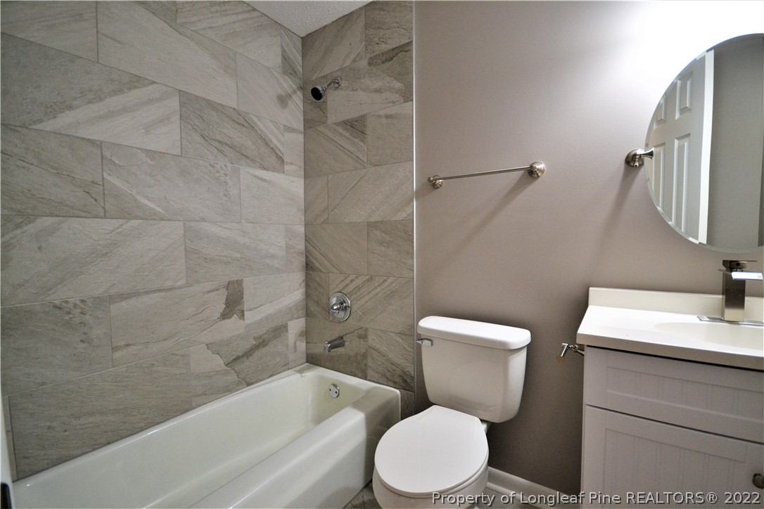 5201 Brookfield Road Fayetteville, NC 28303 - Photo 20 of 45 a white toilet and tub sitting next to a bathroom sink