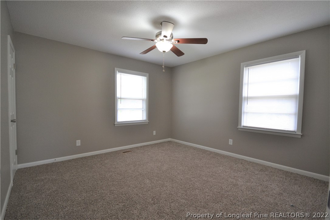 5201 Brookfield Road Fayetteville, NC 28303 - Photo 26 of 45 en empty room with windows and chandelier fan