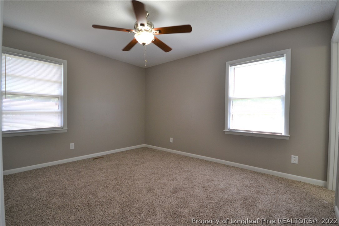 5201 Brookfield Road Fayetteville, NC 28303 - Photo 28 of 45 en empty room with windows and chandelier fan