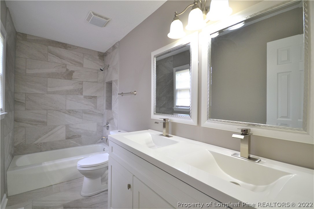 5201 Brookfield Road Fayetteville, NC 28303 - Photo 32 of 45 a bathroom with a sink a toilet and shower